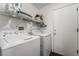 A laundry room featuring white washer and dryer, shelving and hanging rack and exterior door at 3495 Eagle Bend St, Las Vegas, NV 89122