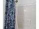 Bright white tiled shower with built in niche and a shower curtain with a blue pattern at 3495 Eagle Bend St, Las Vegas, NV 89122