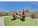 Beautiful backyard featuring well-maintained artificial grass, a seating area, and desert landscaping for outdoor enjoyment at 4523 Herbert River Ave, Las Vegas, NV 89141