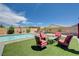 Inviting backyard with a sparkling pool, artificial grass, and a cozy patio seating area for relaxation and entertaining at 4523 Herbert River Ave, Las Vegas, NV 89141