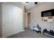 Carpeted bedroom with white closet doors, TV, and ready space for workout at 4523 Herbert River Ave, Las Vegas, NV 89141