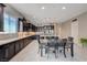 Open kitchen layout with granite counters, stainless appliances, dark cabinetry, and dining area at 4523 Herbert River Ave, Las Vegas, NV 89141