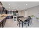 Modern kitchen with granite counters, stainless appliances, dark wood cabinetry, and dining space at 4523 Herbert River Ave, Las Vegas, NV 89141