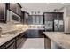 Stylish kitchen features dark wood cabinets, mosaic backsplash, stainless steel appliances, and granite countertops at 4523 Herbert River Ave, Las Vegas, NV 89141