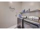 Clean and modern laundry room with updated appliances, storage shelves, and tiled floors at 4523 Herbert River Ave, Las Vegas, NV 89141