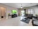 Bright living room with tile flooring, large television, and access to the outdoor pool area at 4523 Herbert River Ave, Las Vegas, NV 89141