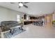 Open-concept living space with tile floors, comfortable seating, and a view of the kitchen and dining area at 4523 Herbert River Ave, Las Vegas, NV 89141