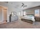 Comfortable bedroom with ceiling fan, carpet flooring, dresser, natural light, and an ensuite bathroom at 4523 Herbert River Ave, Las Vegas, NV 89141