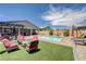 Backyard pool area features ample seating, artificial grass, and stunning views of the property at 4523 Herbert River Ave, Las Vegas, NV 89141