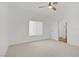 Spacious bedroom featuring a ceiling fan, large window, and door to an ensuite bath at 5112 Harvest Time St # 201, Las Vegas, NV 89130