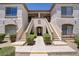 Inviting condo exterior with stucco, stairs, and lush landscaping at 5112 Harvest Time St # 201, Las Vegas, NV 89130