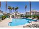 Community pool with palm trees, lounge chairs, and picnic tables at 5112 Harvest Time St # 201, Las Vegas, NV 89130
