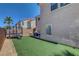 Wide view of the backyard featuring manicured synthetic grass, trampoline, and desert landscaping at 554 Haunts Walk Ave, Las Vegas, NV 89178
