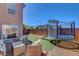 Large backyard with synthetic grass, a trampoline, and an outdoor lounge area at 554 Haunts Walk Ave, Las Vegas, NV 89178