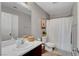 Well-lit bathroom with single sink vanity, framed mirror, and a shower-tub combo at 554 Haunts Walk Ave, Las Vegas, NV 89178