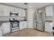 Modern kitchen with stainless steel appliances, white cabinetry, and wood-look tile flooring at 554 Haunts Walk Ave, Las Vegas, NV 89178