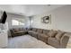 Spacious living room with large sectional sofa, modern decor, and plenty of natural light at 554 Haunts Walk Ave, Las Vegas, NV 89178