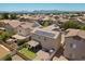 Aerial view of home with solar panels, patio, green grass, and a detached garage at 5656 Fast Payout Ct, Las Vegas, NV 89122