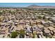 Aerial view of a neighborhood showcasing rooftops with solar panels and a mountain view in the distance at 5656 Fast Payout Ct, Las Vegas, NV 89122