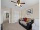 Carpeted bedroom with couch and ottoman, ceiling fan, and natural light from a window at 5656 Fast Payout Ct, Las Vegas, NV 89122