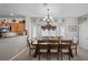 Open dining area with a large table, chandelier, and views of the kitchen and backyard at 5656 Fast Payout Ct, Las Vegas, NV 89122