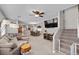 Open-concept living room featuring a large sectional sofa, ceiling fan, and staircase with a baby gate at 5656 Fast Payout Ct, Las Vegas, NV 89122