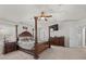 A main bedroom features a four-poster bed, ceiling fan, dresser, and neutral carpeting at 5656 Fast Payout Ct, Las Vegas, NV 89122