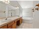 Bright bathroom features a double sink vanity, a soaking tub, and a separate glass-enclosed shower at 5981 Doubletree Rd, Pahrump, NV 89061