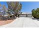 Home exterior with a long concrete driveway leading to a two-car garage and mature landscaping in the front yard at 5981 Doubletree Rd, Pahrump, NV 89061