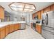 A spacious kitchen boasts stainless steel appliances, wood cabinets, tile countertops, and a unique lighting fixture at 5981 Doubletree Rd, Pahrump, NV 89061