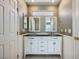 Bathroom with dual sinks, white cabinets, and decorative mirrors at 6125 Broken Slate Way, Las Vegas, NV 89139