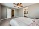 Spacious bedroom with ceiling fan, carpeted floor, and open bathroom doorway at 6125 Broken Slate Way, Las Vegas, NV 89139
