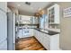 Bright kitchen featuring stainless steel appliances, white cabinets, granite countertops, and hardwood floors at 6125 Broken Slate Way, Las Vegas, NV 89139