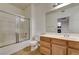 Bathroom with tub shower combo, oak cabinets, sink, and large mirror at 6160 Rumrill St # 202, Las Vegas, NV 89113