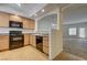 Eat-in kitchen features wood cabinets, black appliances, and breakfast bar with sight lines to the living room at 6160 Rumrill St # 202, Las Vegas, NV 89113