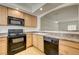 Kitchen features wood cabinets, black appliances, laminate counters, and an eat-in breakfast bar at 6160 Rumrill St # 202, Las Vegas, NV 89113