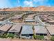 An aerial view of homes in a community with desert landscaping, sidewalks and mountain views at 64 Lake Oasis St, Henderson, NV 89011