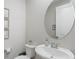 Elegant powder room with pedestal sink, oval mirror, and decorative accents at 64 Lake Oasis St, Henderson, NV 89011
