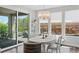 Chic dining area with contemporary light fixture and backyard views from large sliding glass door at 64 Lake Oasis St, Henderson, NV 89011