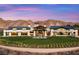 A sprawling home exterior with a huge lawn, outdoor seating, and desert mountain backdrop at 64 Lake Oasis St, Henderson, NV 89011