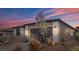 Charming home with a gray exterior, black garage door and desert landscaping at 64 Lake Oasis St, Henderson, NV 89011