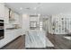 Bright kitchen with white cabinets, stainless appliances, pendant lights and large island at 64 Lake Oasis St, Henderson, NV 89011