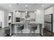 Bright kitchen with white cabinets, stainless appliances, pendant lights and large island at 64 Lake Oasis St, Henderson, NV 89011