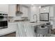 Bright kitchen with white cabinets, stainless appliances, pendant lights and large island at 64 Lake Oasis St, Henderson, NV 89011