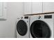 Modern laundry room features white cabinetry and front load washer and dryer at 64 Lake Oasis St, Henderson, NV 89011
