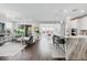 Bright, open-concept living space with hardwood floors seamlessly connecting to the kitchen and dining area at 64 Lake Oasis St, Henderson, NV 89011