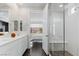 Bright main bathroom with double vanity, walk-in shower, and view into the bedroom at 64 Lake Oasis St, Henderson, NV 89011