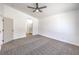 Spacious bedroom with neutral carpeting, ceiling fan, and an arched entry to bathroom at 6456 First View Ave, Las Vegas, NV 89142