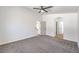Spacious bedroom with neutral carpeting, ceiling fan, and an arched entry to bathroom at 6456 First View Ave, Las Vegas, NV 89142