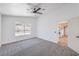 Bright bedroom with ceiling fan, neutral carpet, and view to backyard at 6456 First View Ave, Las Vegas, NV 89142